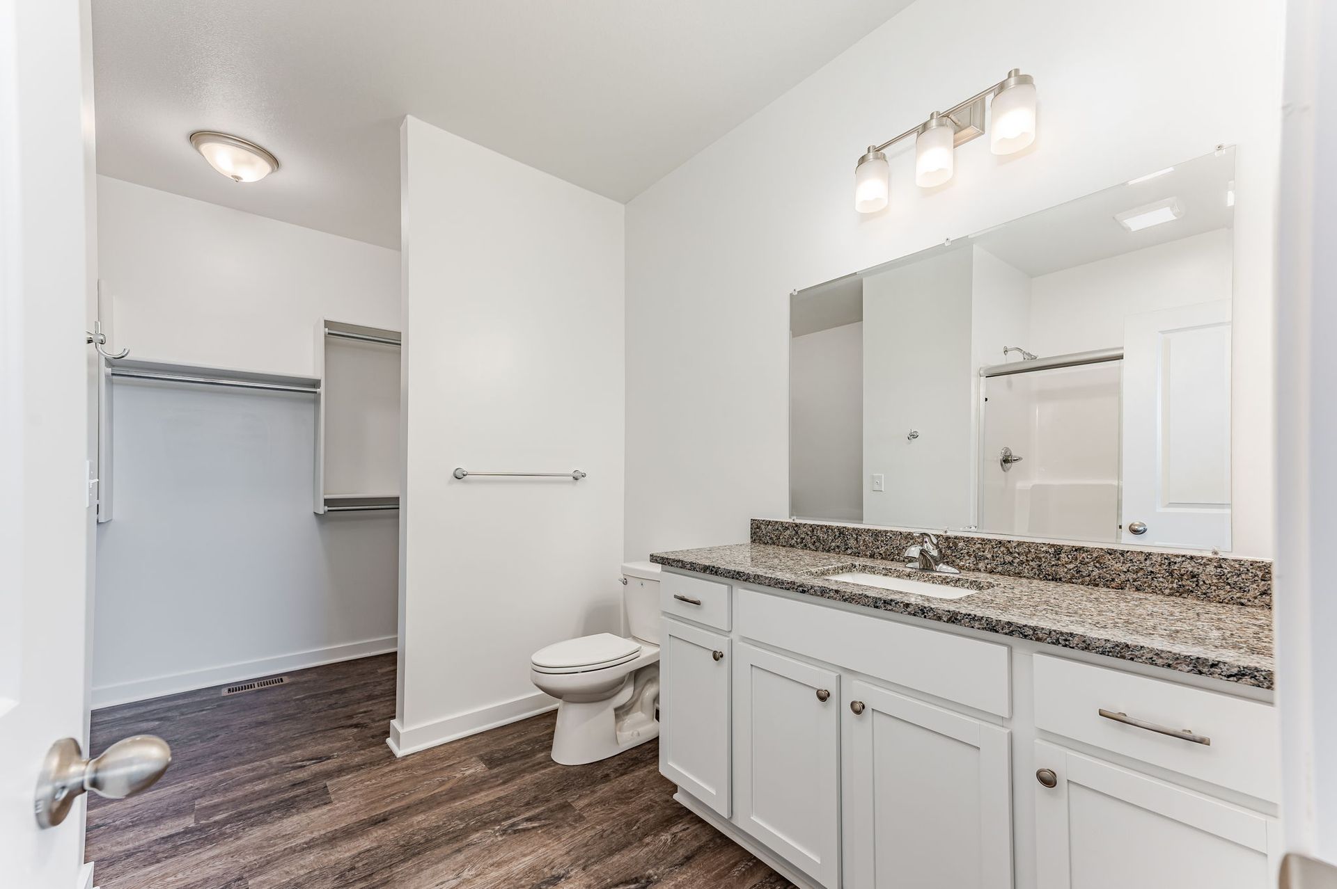 A bathroom with a toilet , sink , and mirror.