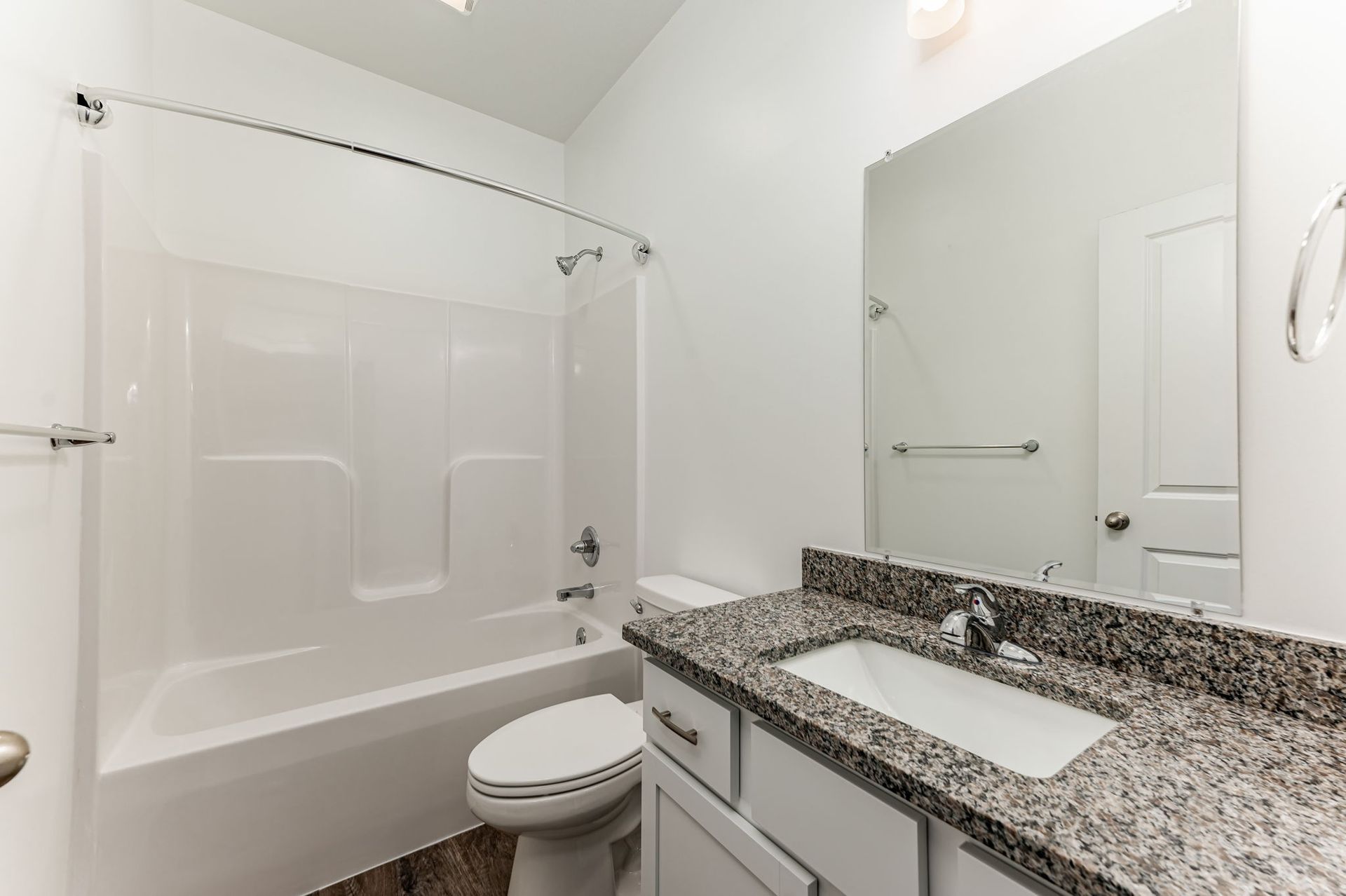 A bathroom with a toilet , sink , bathtub and mirror.