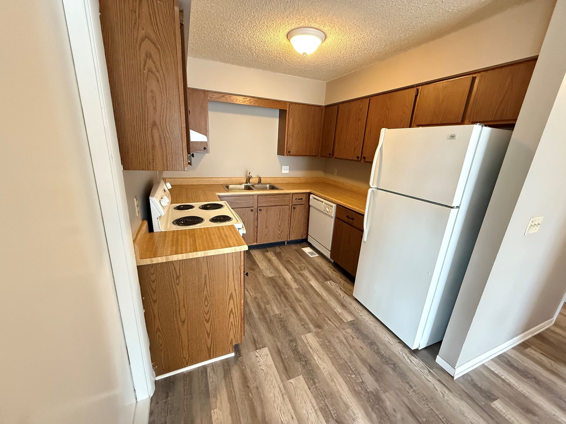 A kitchen with wooden cabinets and a white refrigerator.
