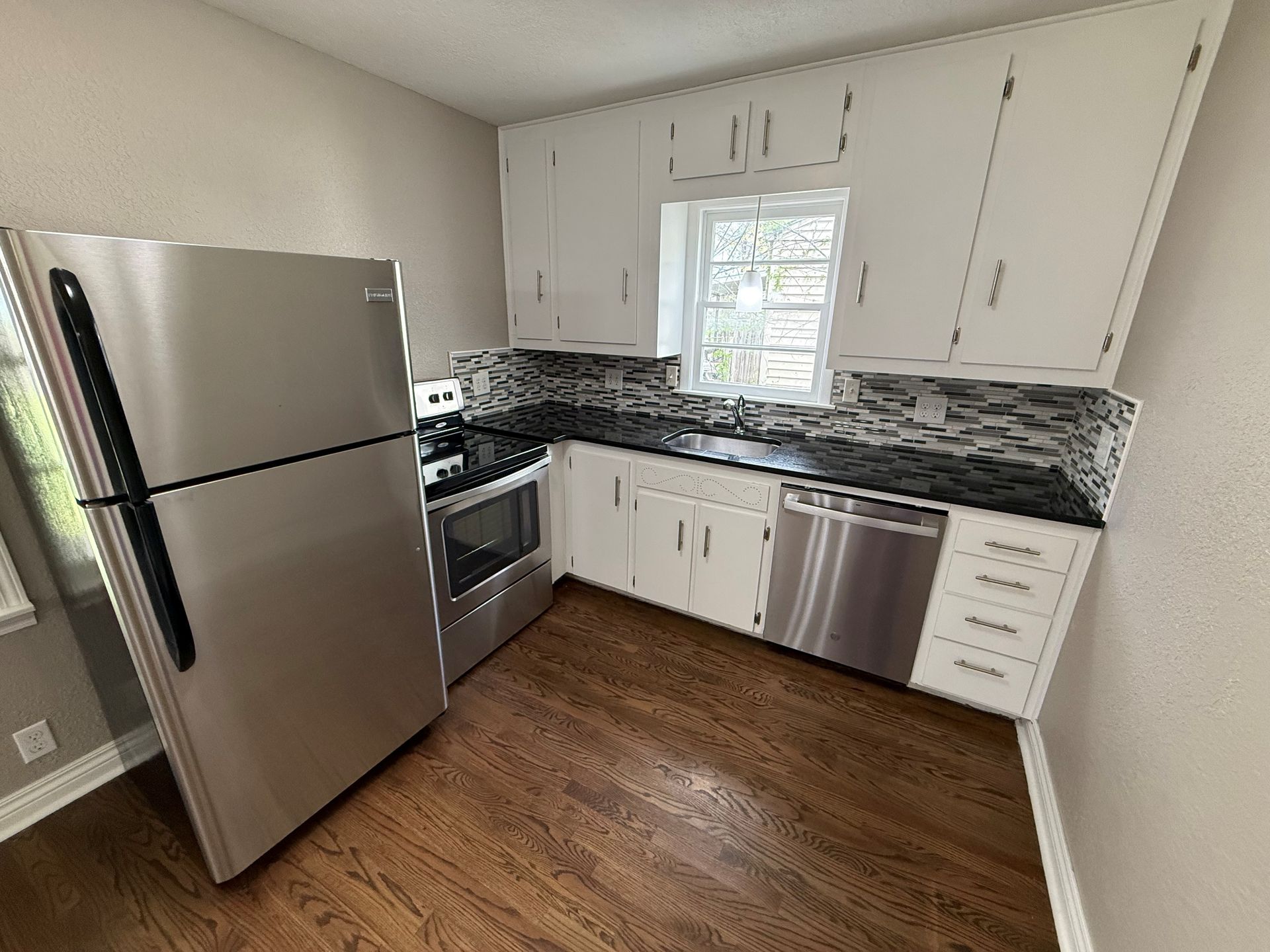 A kitchen with stainless steel appliances and white cabinets