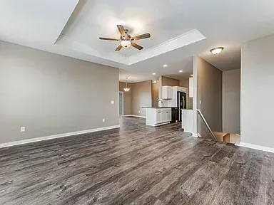A living room with hardwood floors and a ceiling fan.