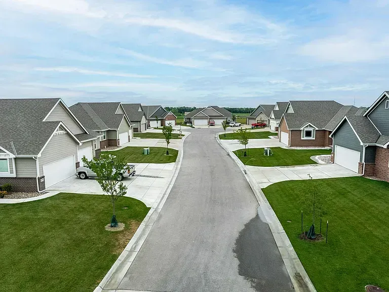 An aerial view of a residential neighborhood with lots of houses and a road.