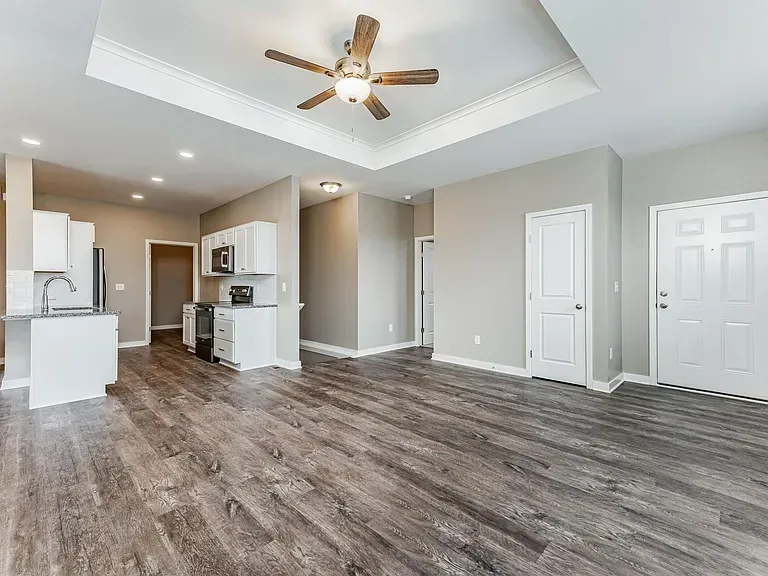 A living room with hardwood floors and a ceiling fan.