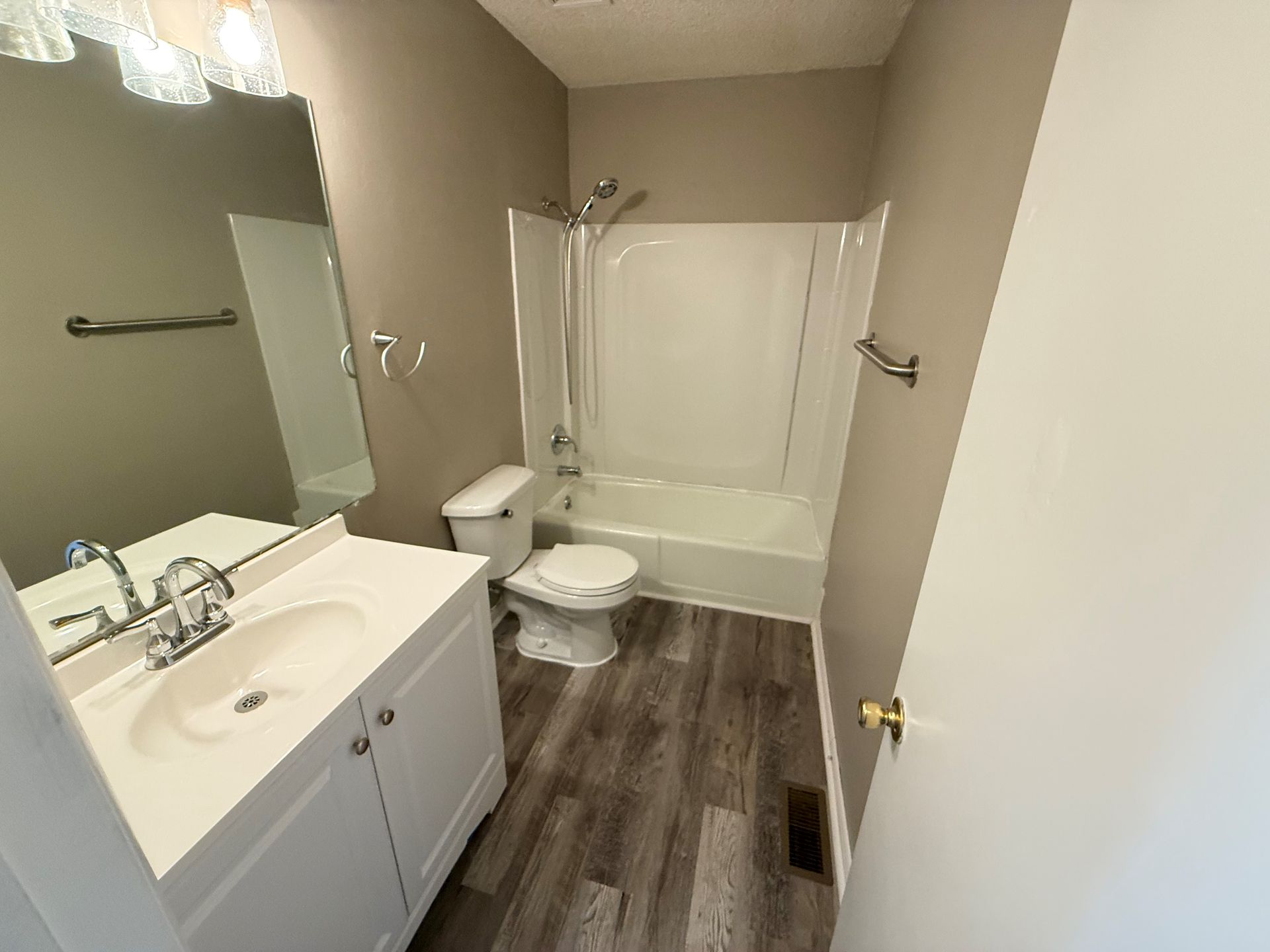 A bathroom with a toilet , sink , and bathtub.