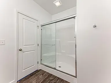 A bathroom with a sliding glass shower door.