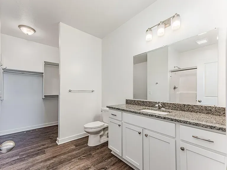 A bathroom with a toilet , sink , and mirror.