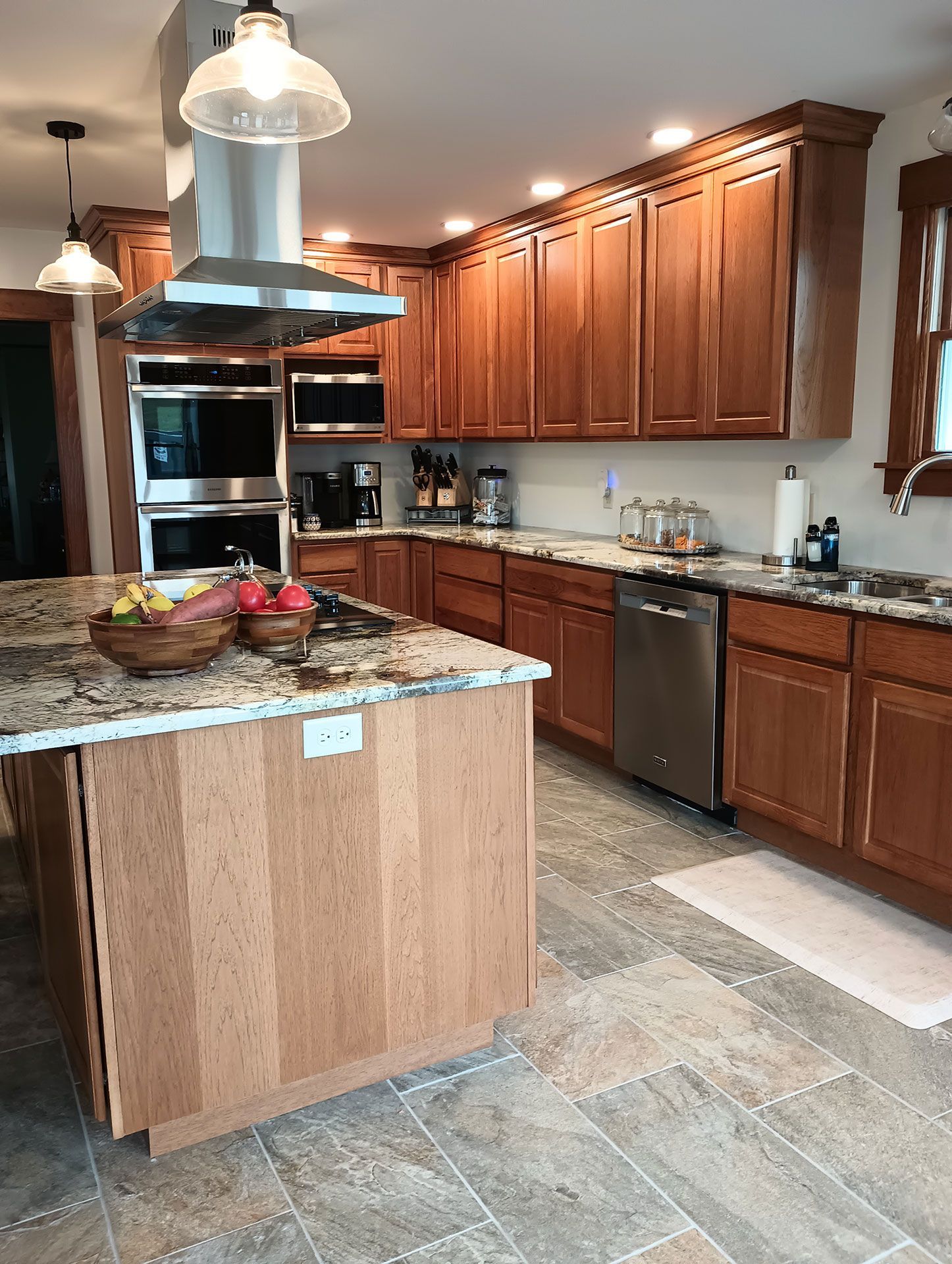 kitchen with wooden cabinets, granite counter tops, stainless steel appliances, and a large island