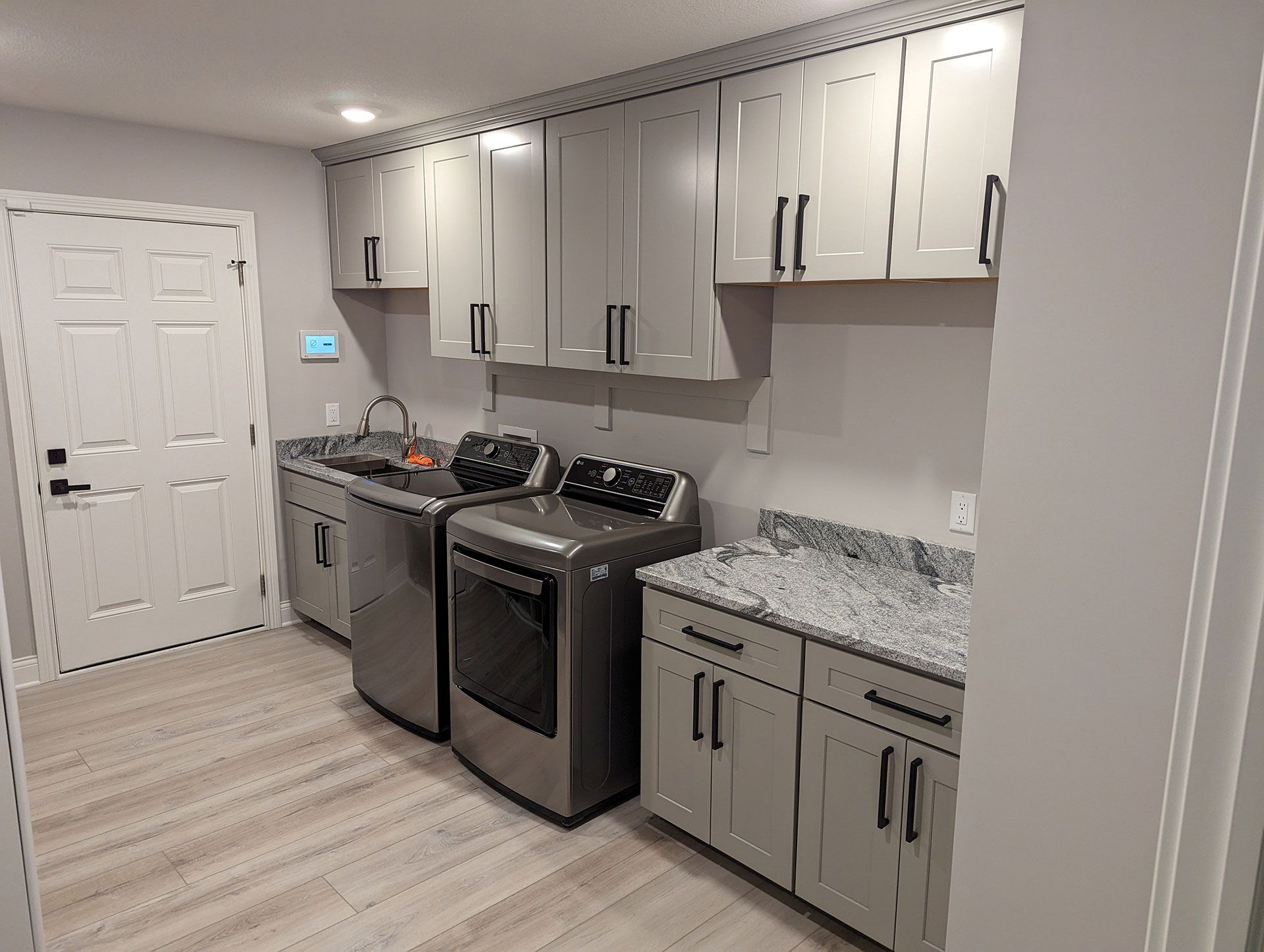 A laundry room with a washer and dryer and a sink.