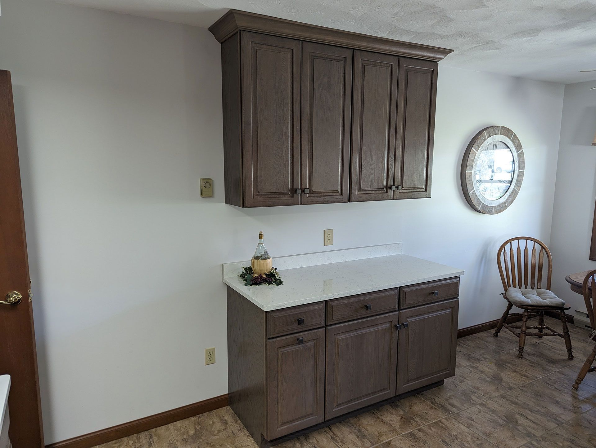 A kitchen with gray cabinets and a white counter top
