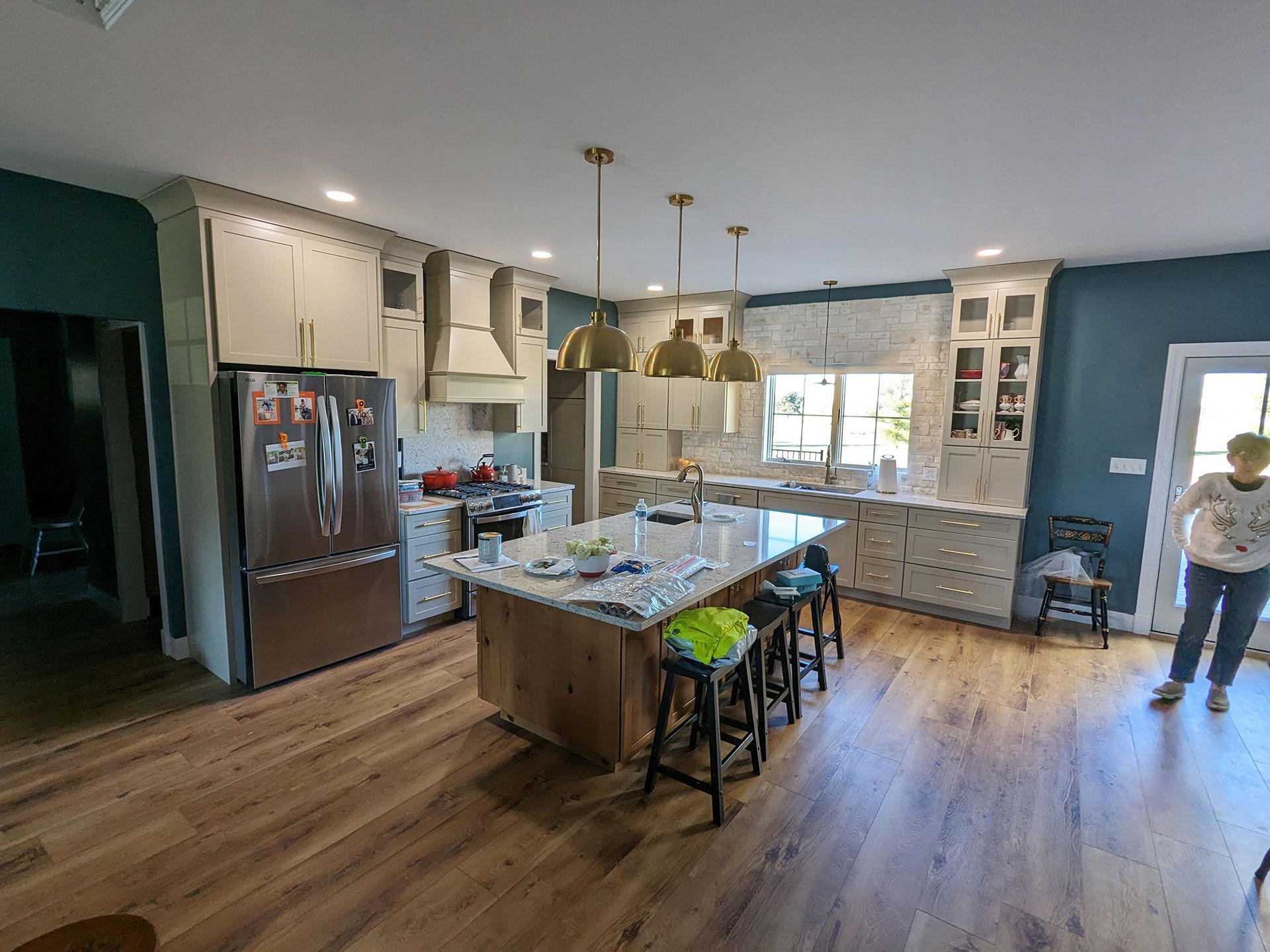 A woman is standing in a kitchen with a large island in the middle