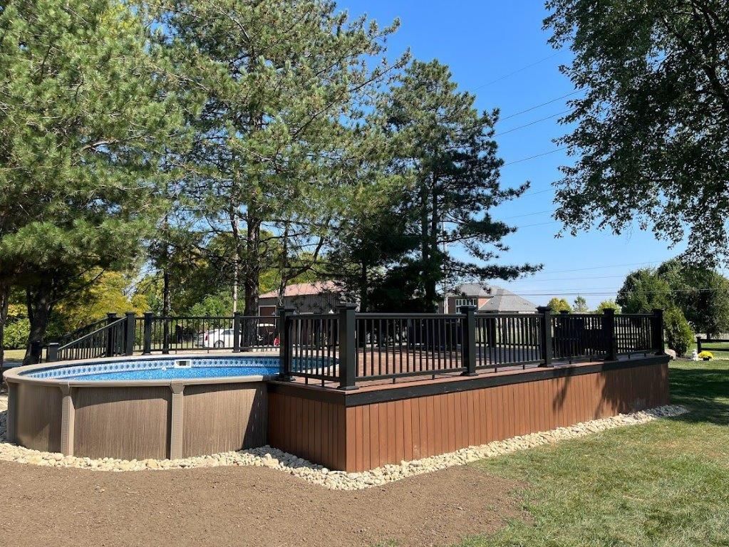 An outdoor swimming pool with a wooden deck