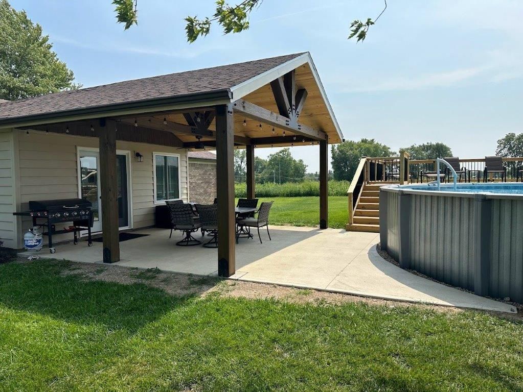 A house with a covered patio and a pool in the backyard