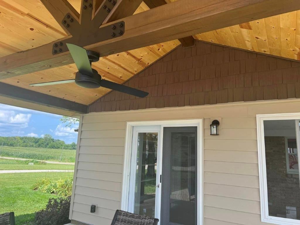 A house featuring a spacious patio cover with a ceiling fan