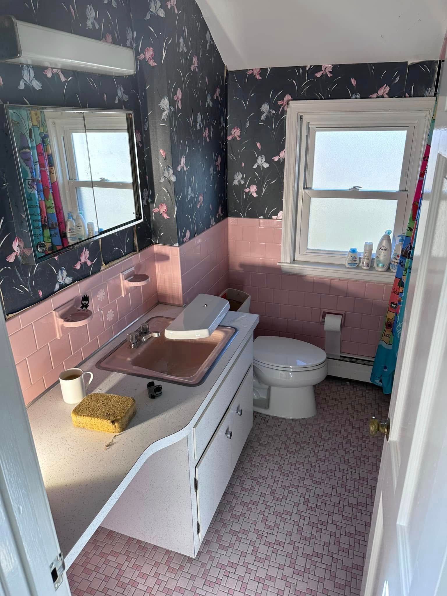 A bathroom with a sink, toilet, and mirror.