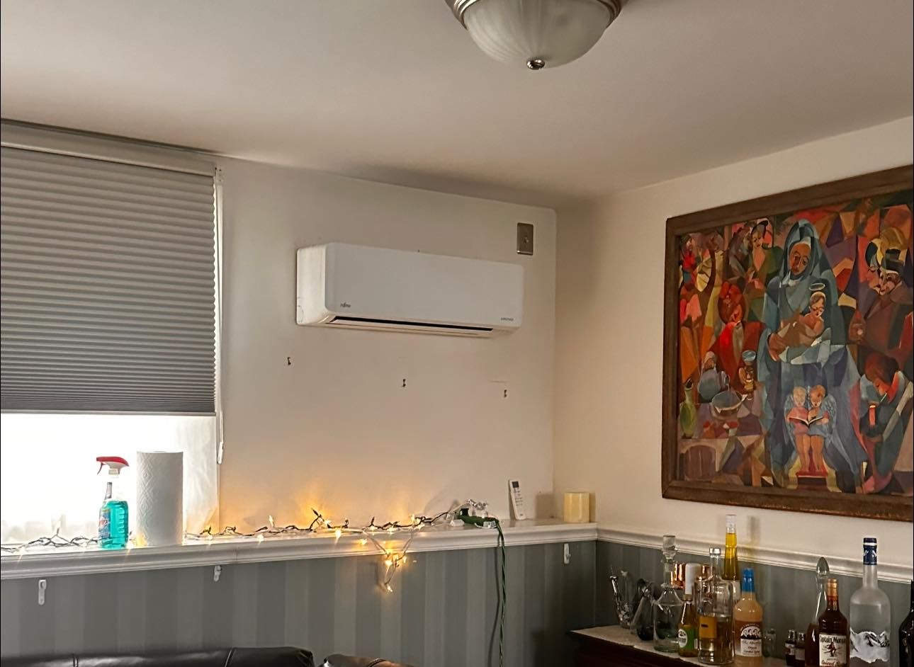 A living room with a painting on the wall and a couch.