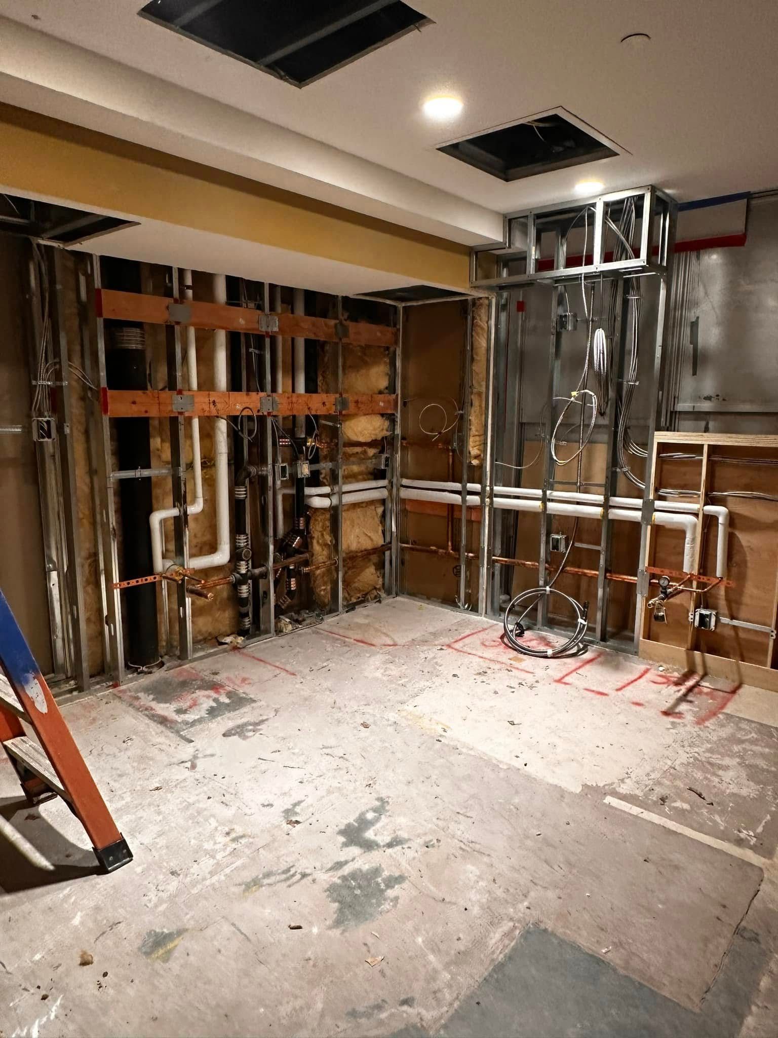 A room under construction with a ladder in the middle of it.