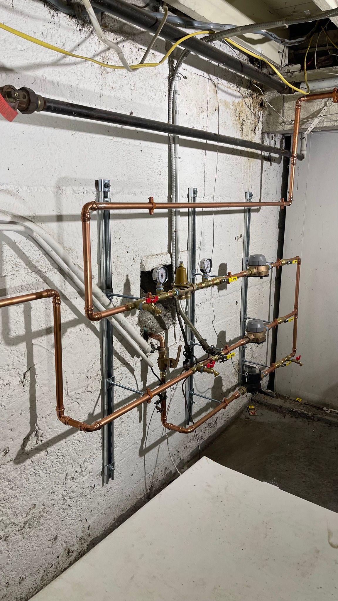 A room with copper pipes hanging on a wall.