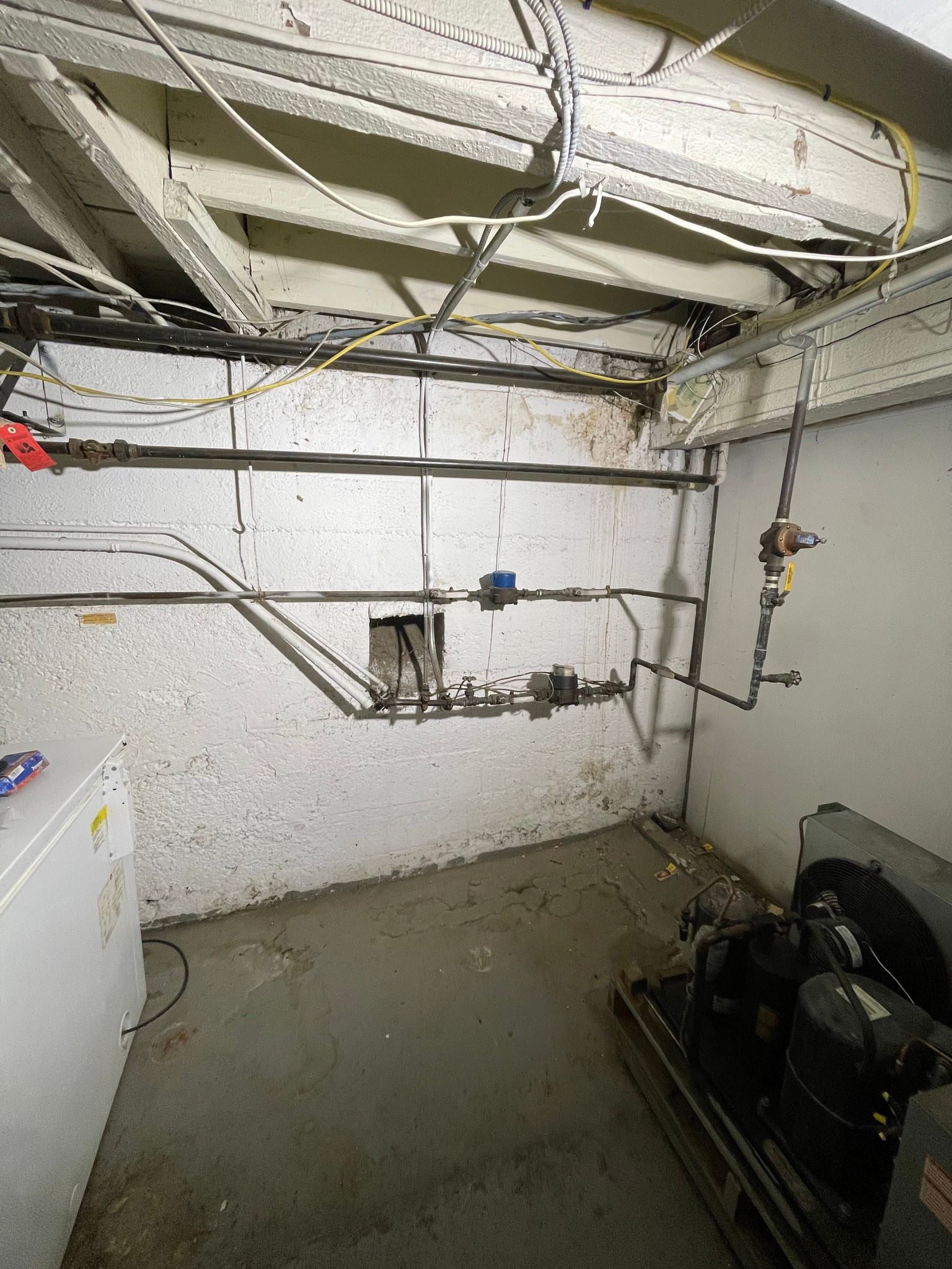 A room with a lot of pipes and wires hanging from the ceiling.