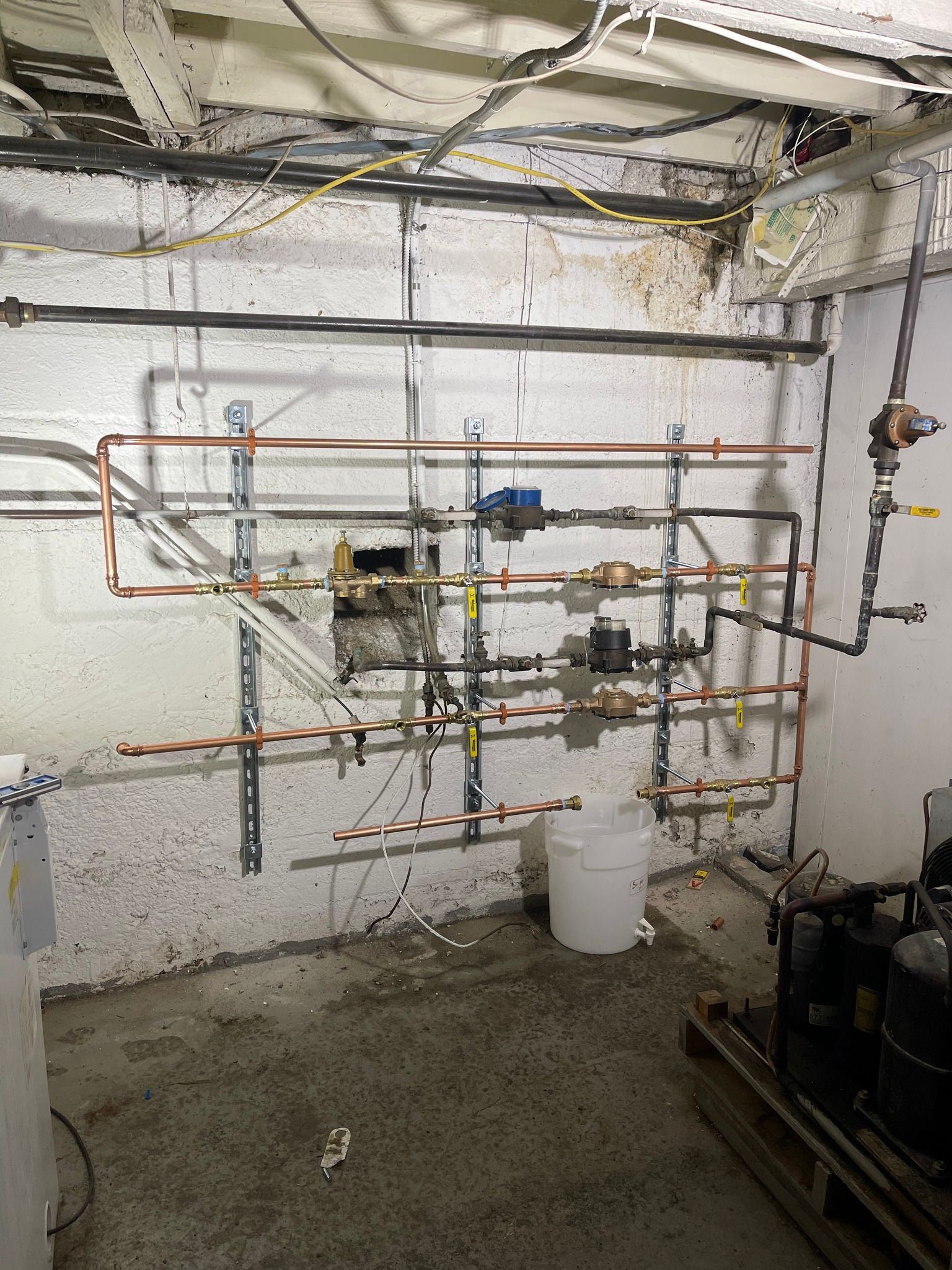 A room with a lot of pipes hanging on the wall.