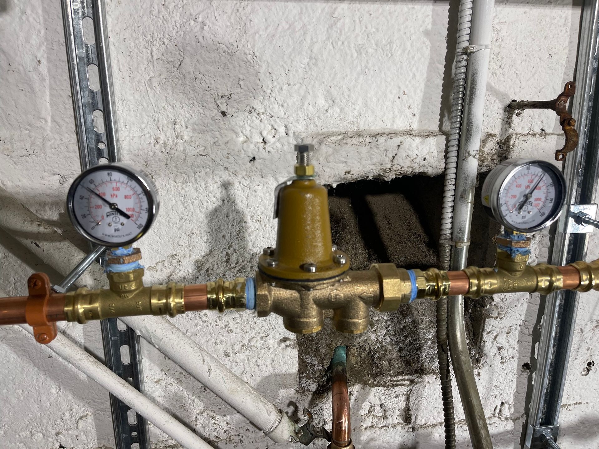 Two pressure gauges are attached to a brass pipe.