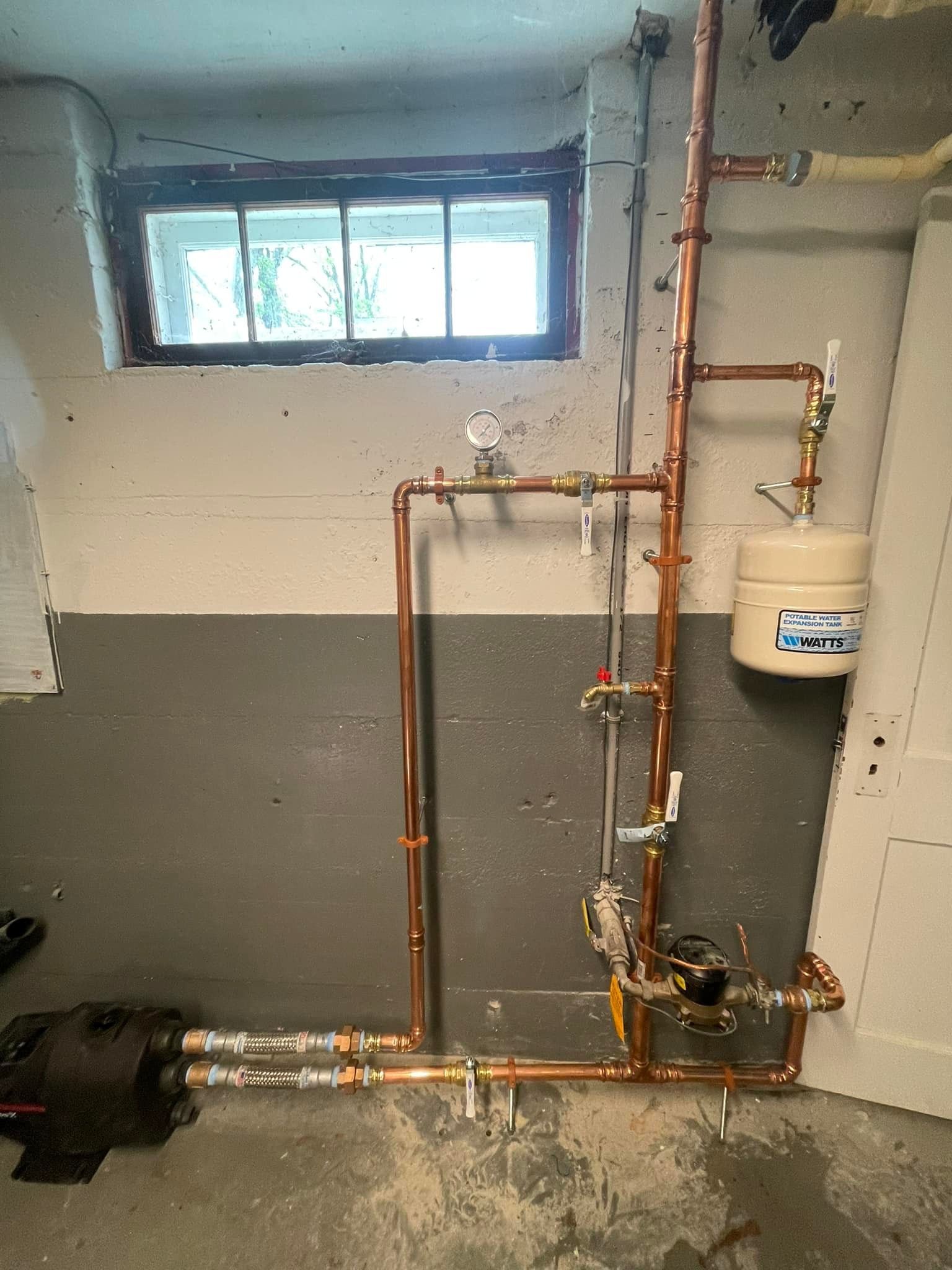 A room with a lot of pipes and a window.