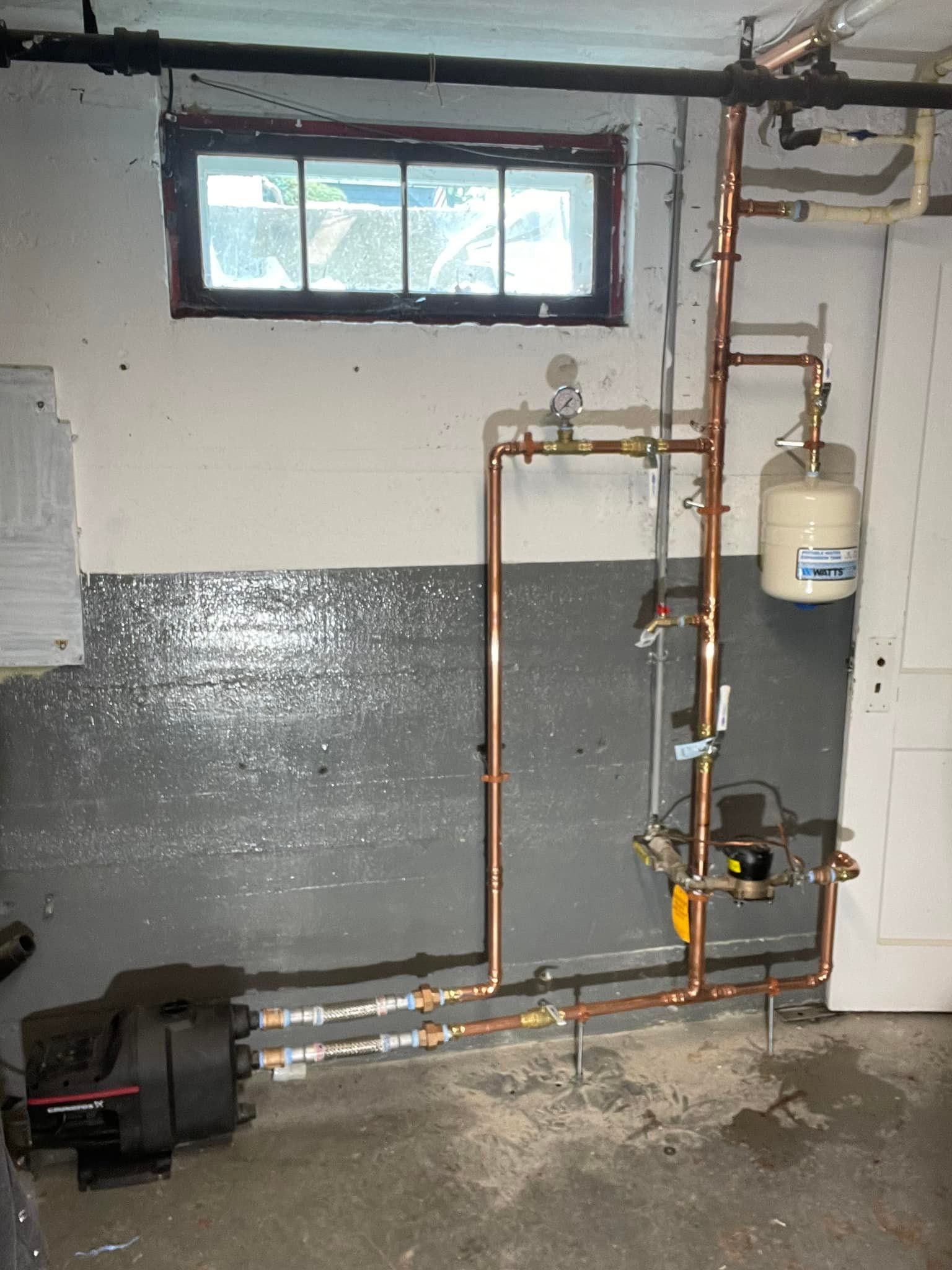 A room with a lot of pipes and a window