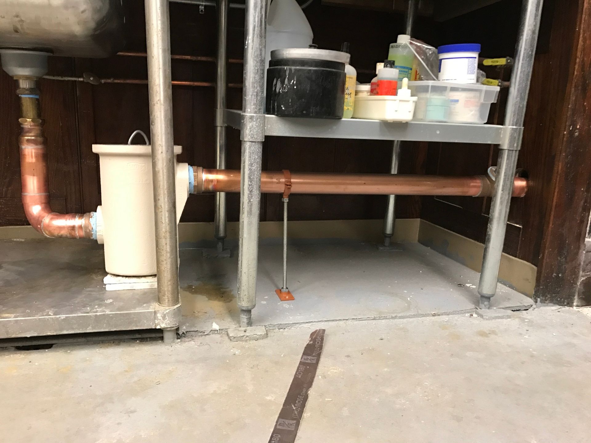 A sink with a copper pipe underneath it