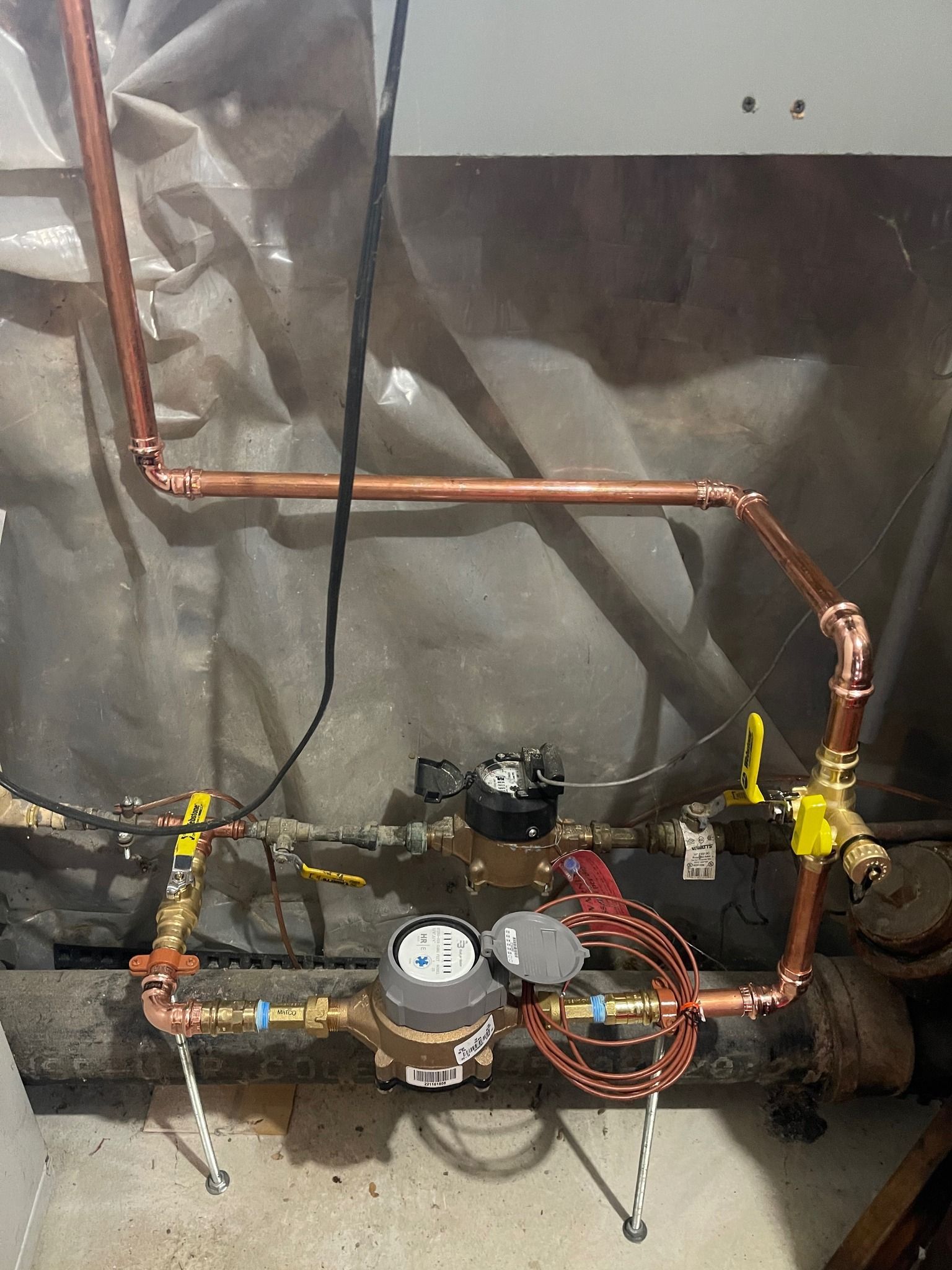 A copper pipe with a water meter attached to it.