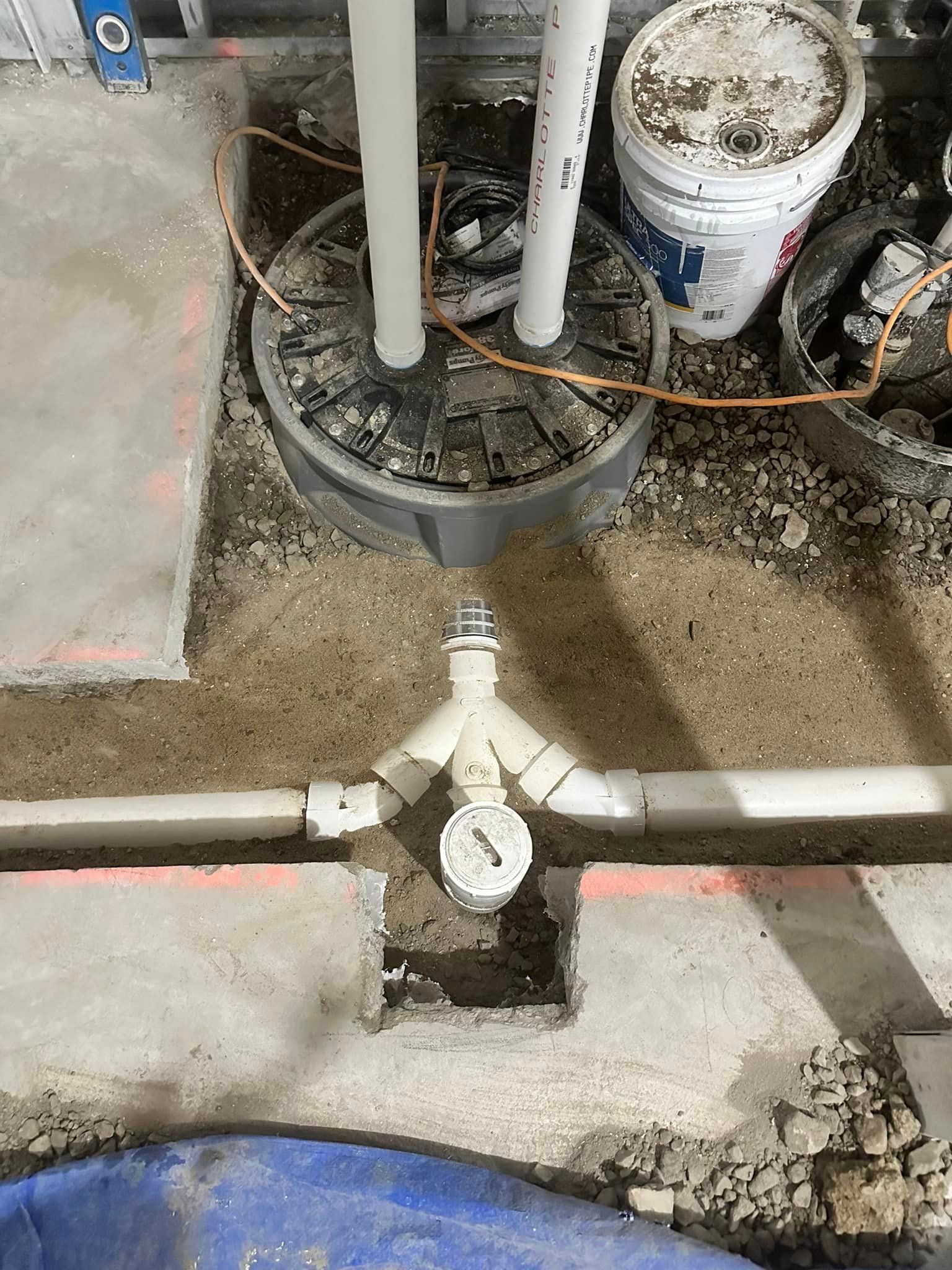 A drain pipe is being installed in a basement.