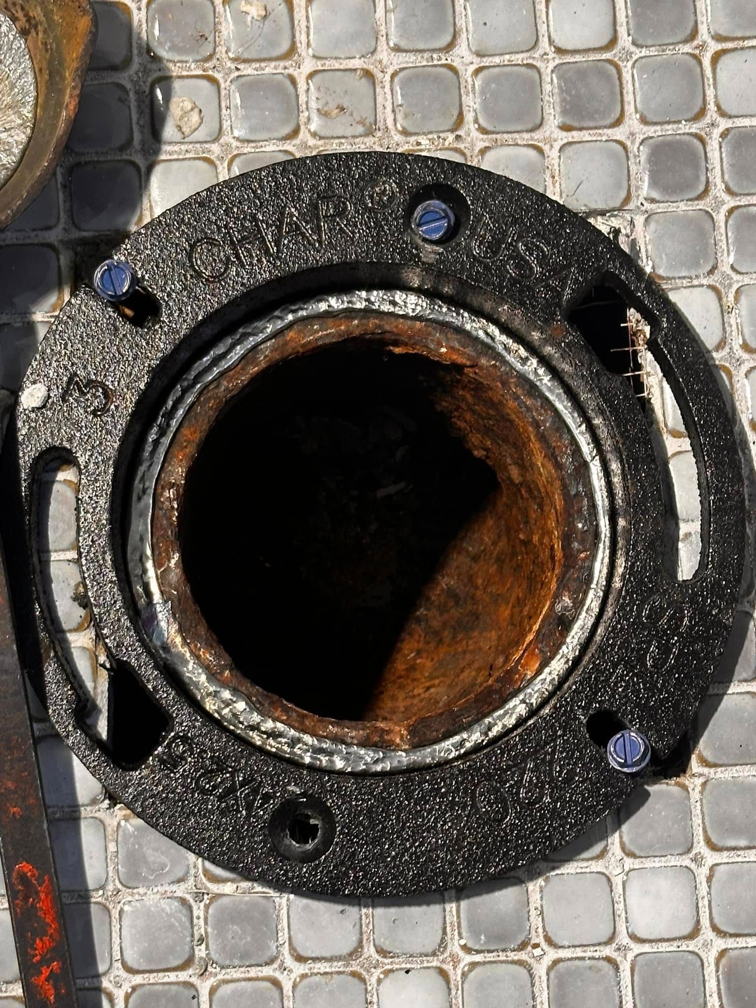 A close up of a rusty pipe on a tiled floor