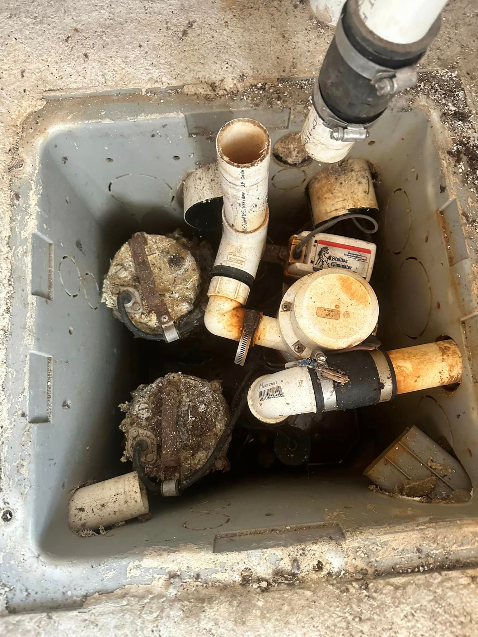 A bunch of pipes are sitting in a manhole cover.