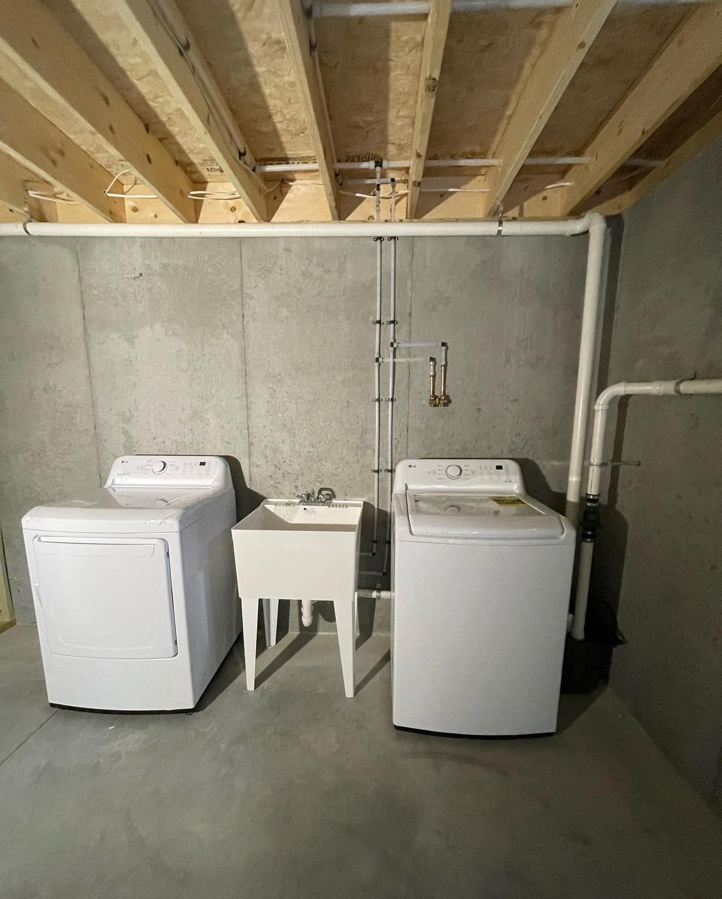 A laundry room with a washer and dryer and a sink.