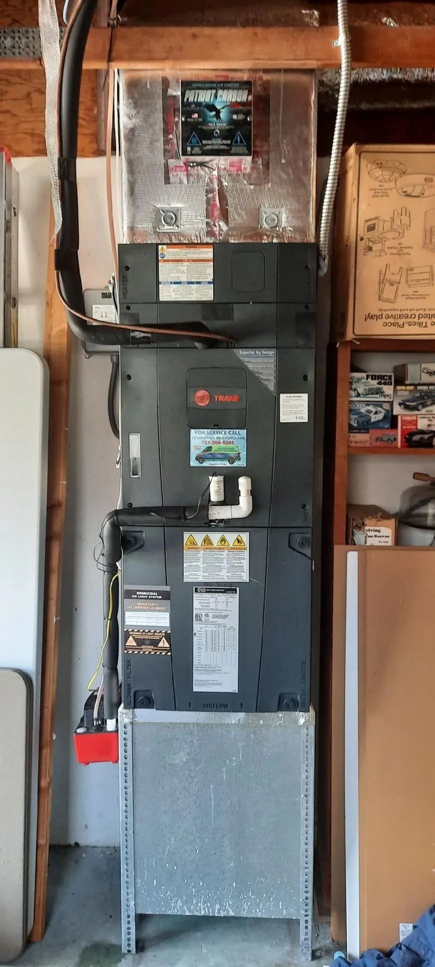 Electrical breaker panel mounted on a wall in a utility closet with exposed wiring and metal conduit.