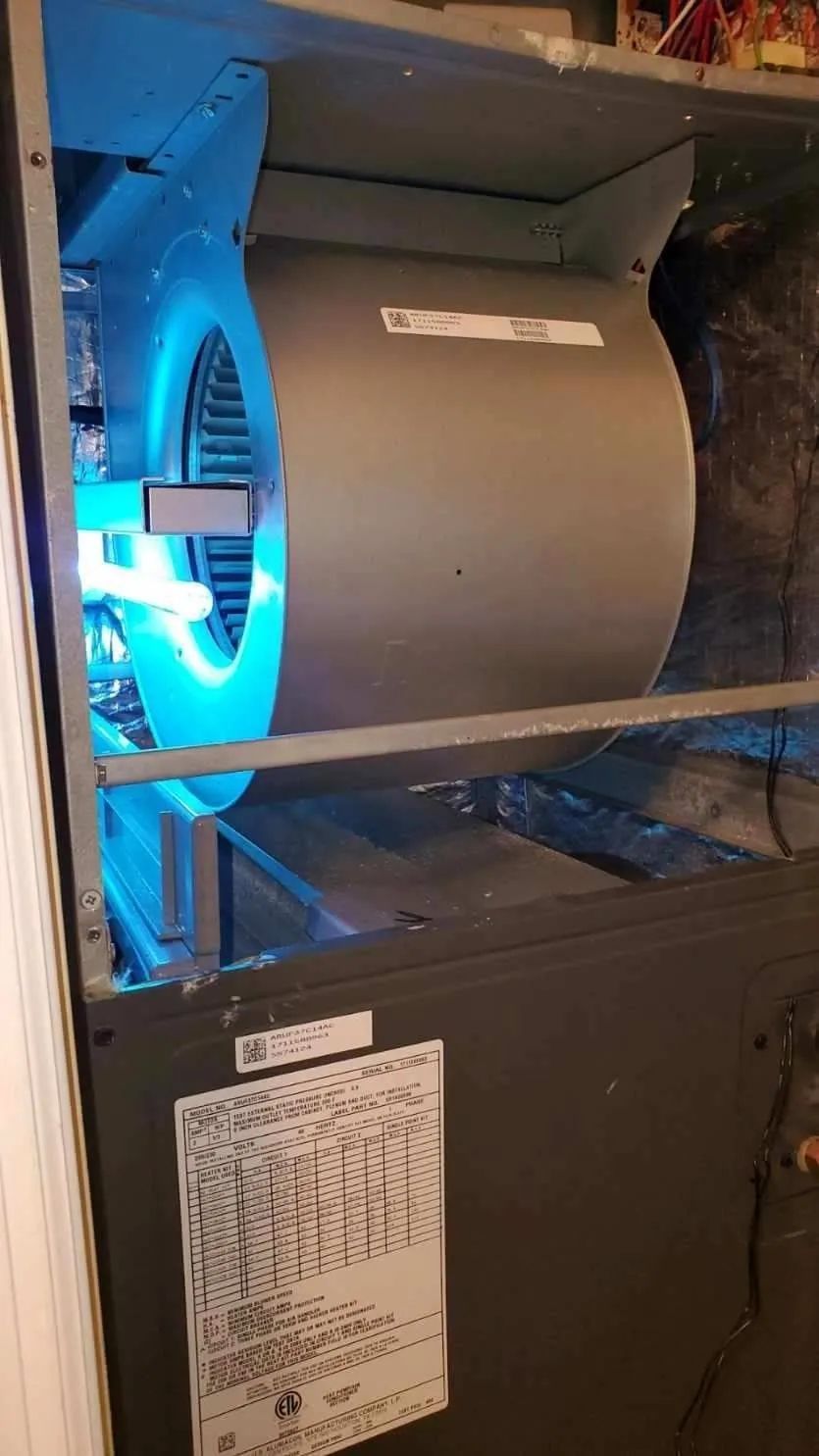 Blue-lit computer case interior with a large gray fan and power supply label visible