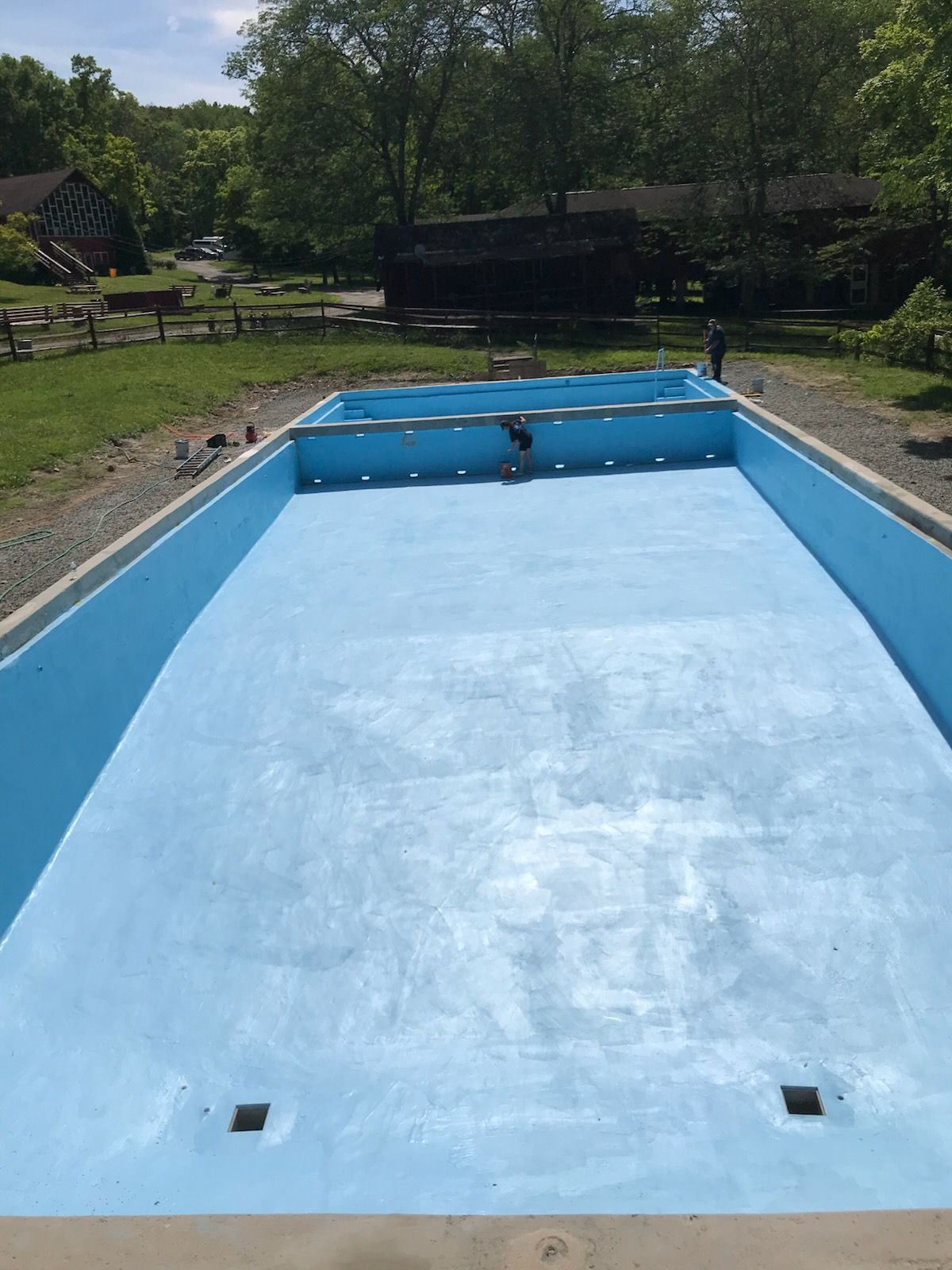 A large blue swimming pool is being built in a backyard.