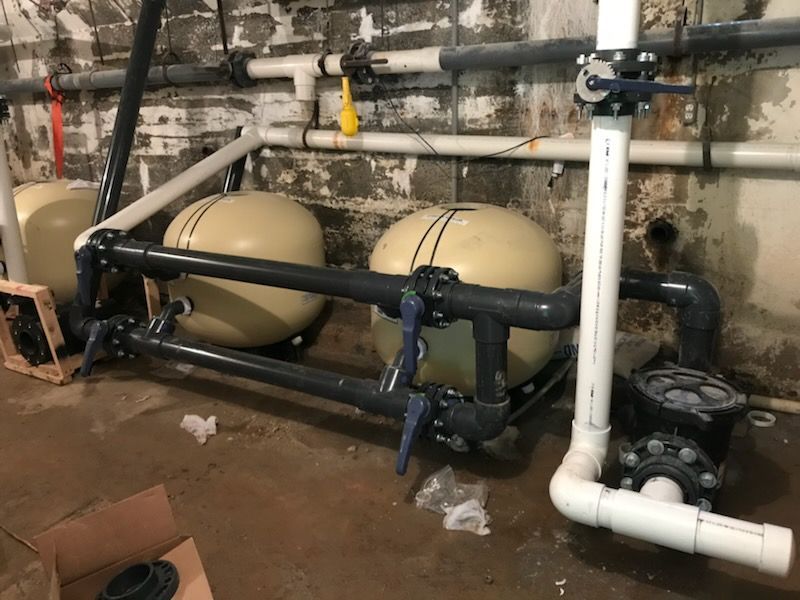 A room with a lot of pipes and water pumps