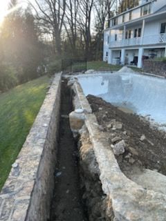 A swimming pool is being built in the backyard of a house.