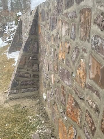 A stone wall with a triangle in the middle of it.