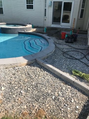 A swimming pool is being built in the backyard of a house.