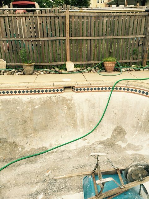 A swimming pool with a green hose attached to it