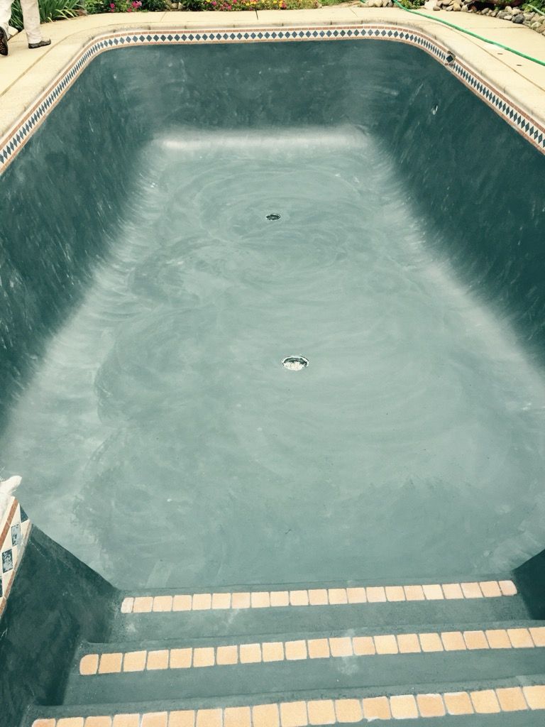 A large swimming pool with a drain in the middle of it.