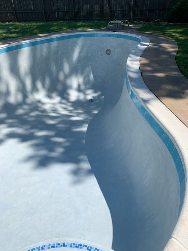 A swimming pool with a shadow of trees on it