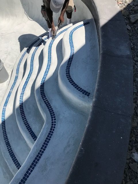 A person is working on a swimming pool staircase
