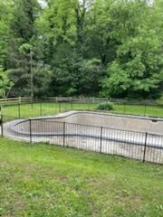 A large swimming pool surrounded by a fence in a backyard.