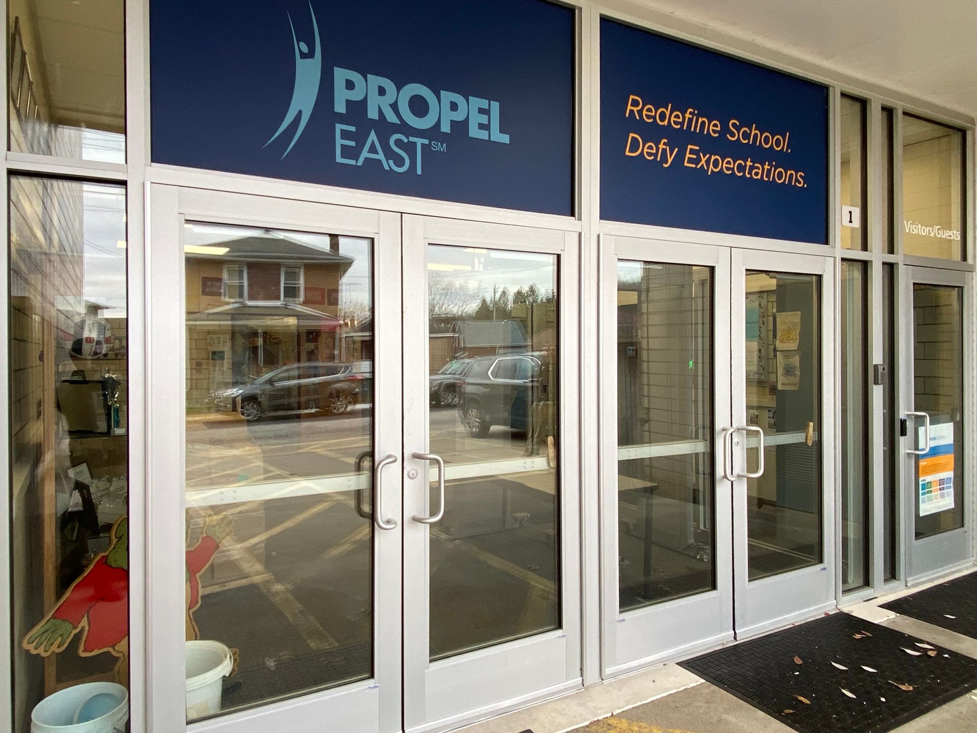 The front door of a building with a sign that says propel east.