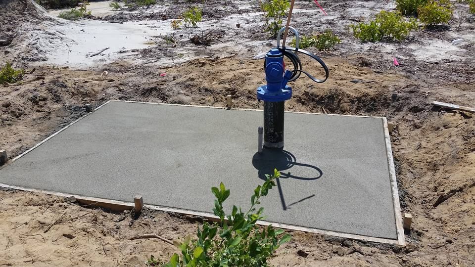 A blue fire hydrant is sitting on top of a concrete slab.