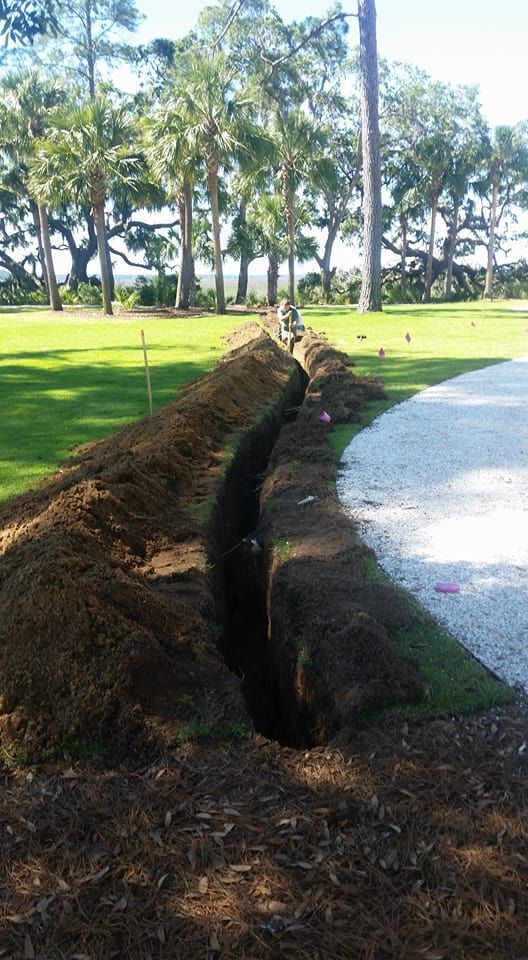 A hole in the ground in the middle of a grassy field.