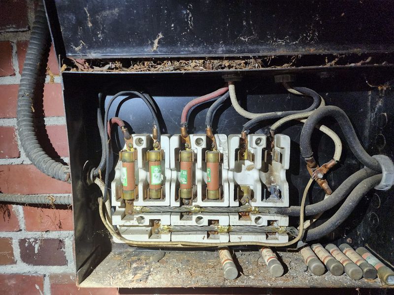 An old electrical box with a bunch of wires coming out of it