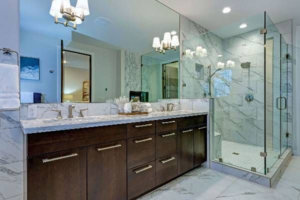 A bathroom with two sinks and a walk in shower.