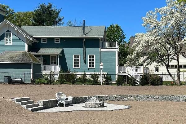 A blue house with a fire pit in front of it
